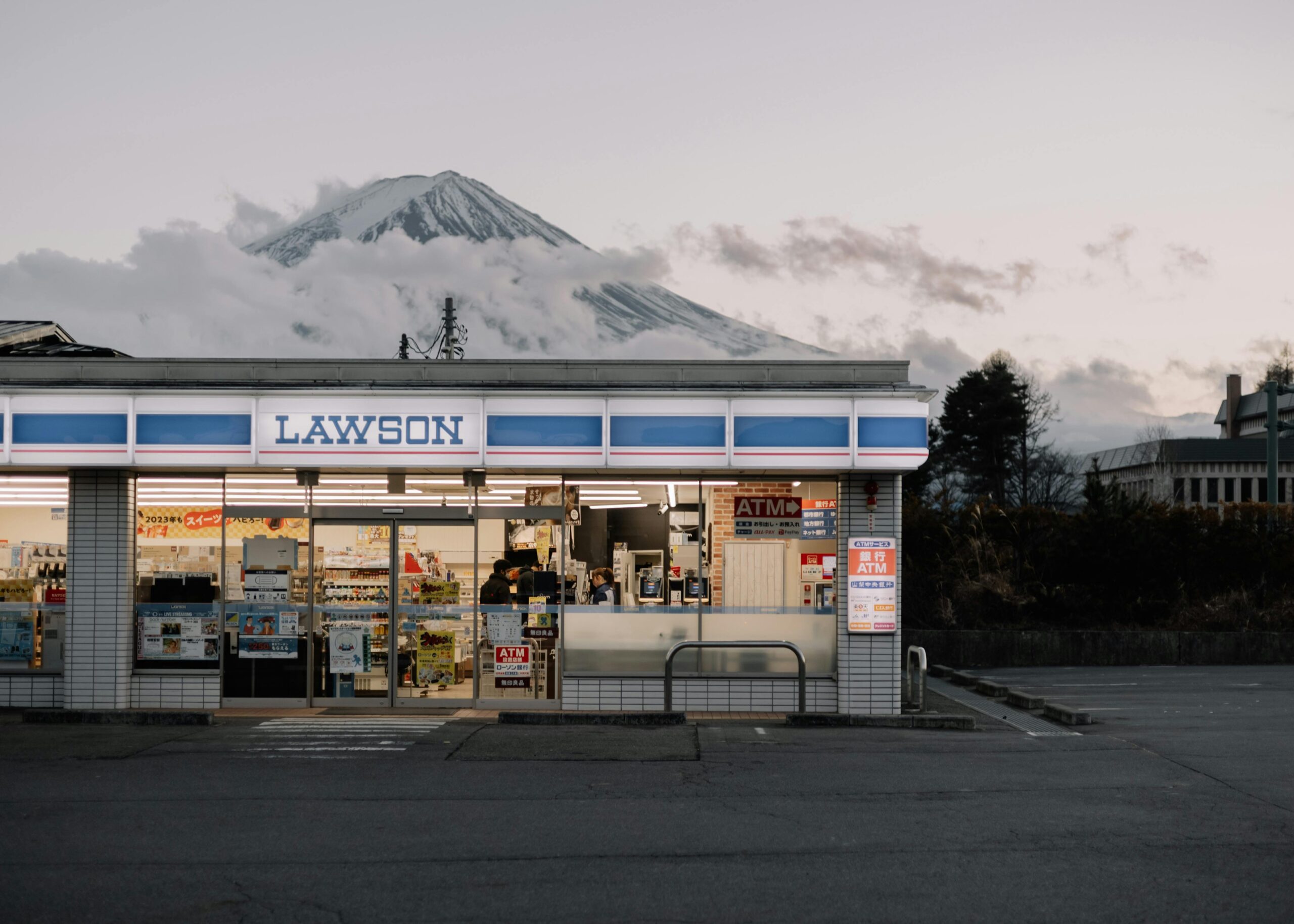 Lawson store with Mount Fuji in the background during day, showcasing urban convenience and natural beauty.